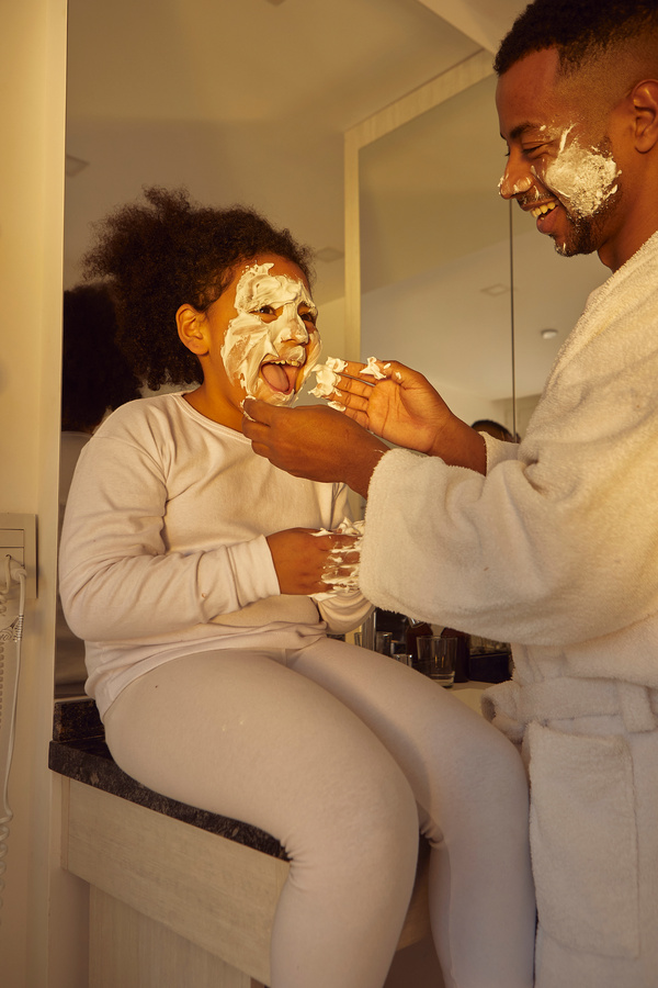 Playful Dad and Daughter Playing with Facial Cream